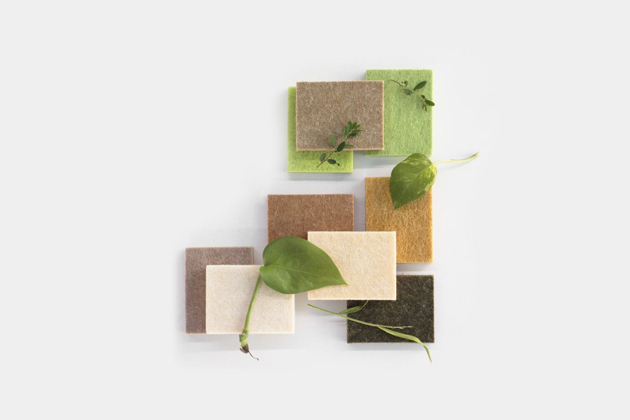 Nine square fabric swatches in neutral and green tones are arranged in a grid on a white background, with small green leaves and vines placed among them, evoking the natural inspiration behind our FSC Chain of Custody Wall Panels.