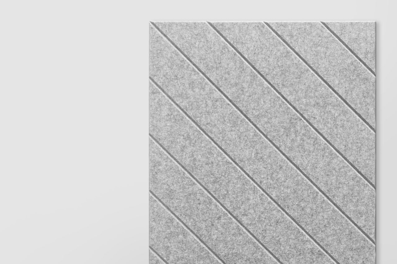 A rectangular gray polyester acoustic panel with diagonal grooves, positioned on the right side of a plain light background, showcases our Polyester Acoustic Panels offerings.