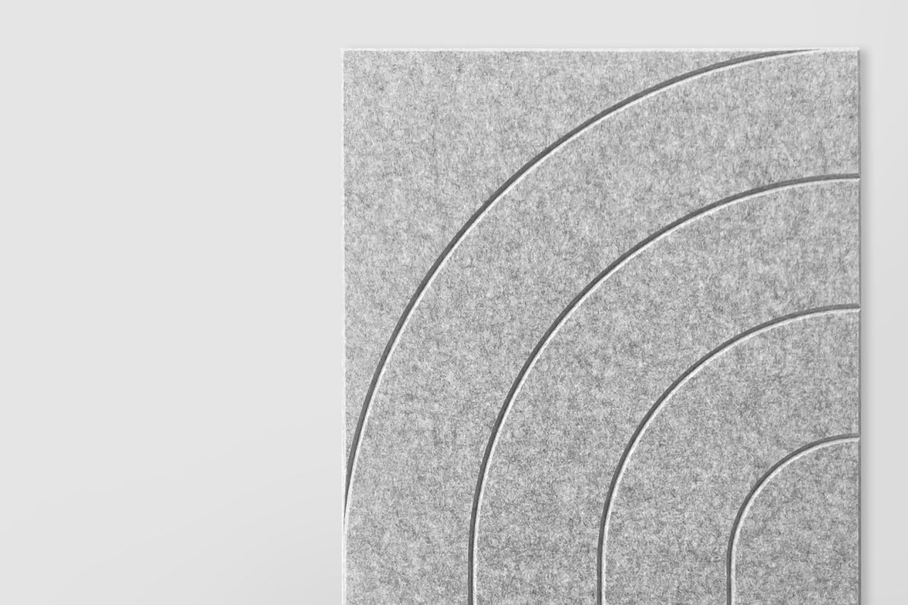 A rectangular gray textured panel from our Polyester Acoustic Panels Offerings features three embossed curved lines forming partial concentric arcs, set against a plain light background.