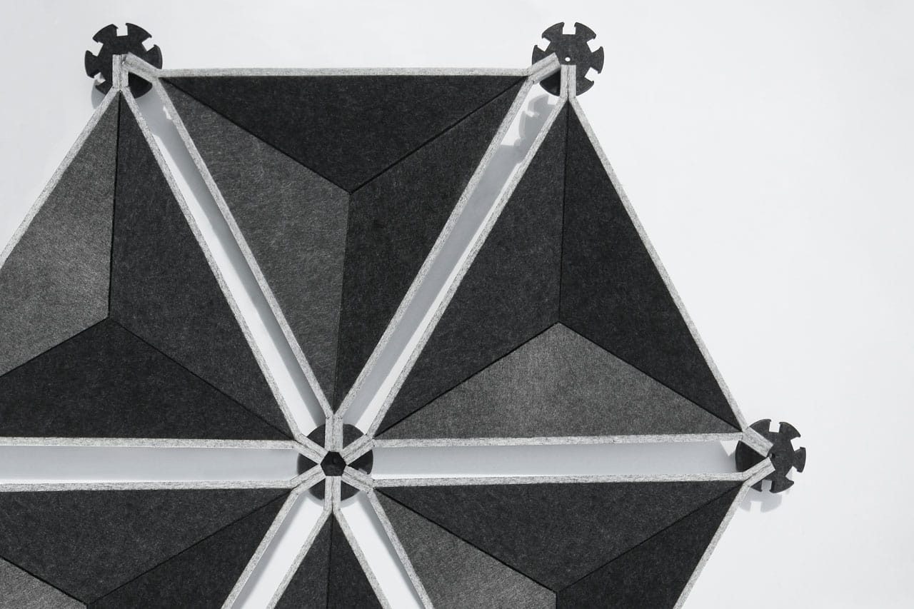 Geometric pattern with interlocking black and gray triangular shapes forming a hexagonal design, connected by round, gear-like connectors at the corners—perfect for modern Polyester Acoustic Panels Offerings—set against a white background.
