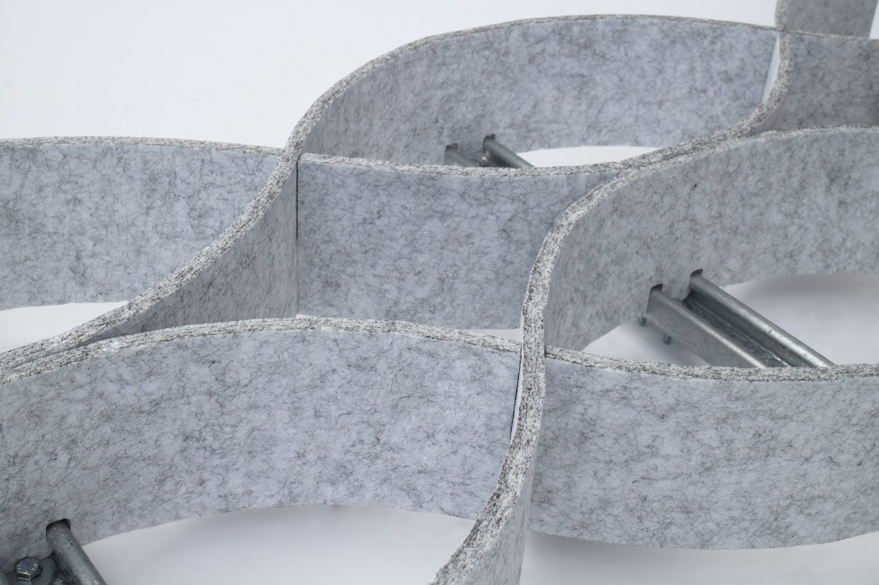 Close-up of intersecting, curved gray polyester acoustic panels offerings with a felt-like texture, connected by metal rods on a white background. The panels form a pattern of intertwined loops.